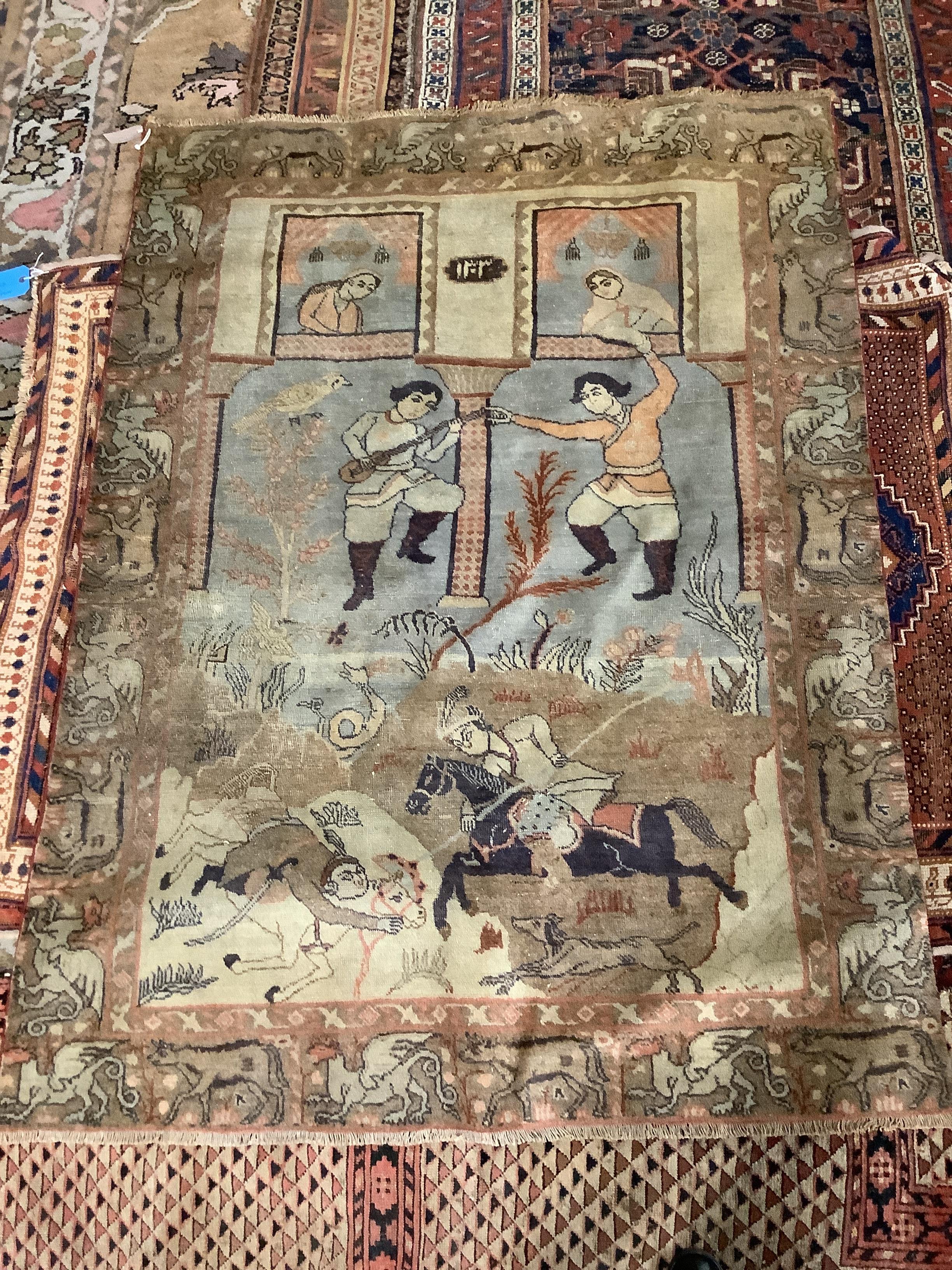A Persian pictorial rug, depicting dancing musicians and warriors, with women looking on from above, 164 x 119cm